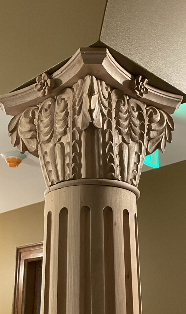 Closeup of carved matching capital at the top of column.